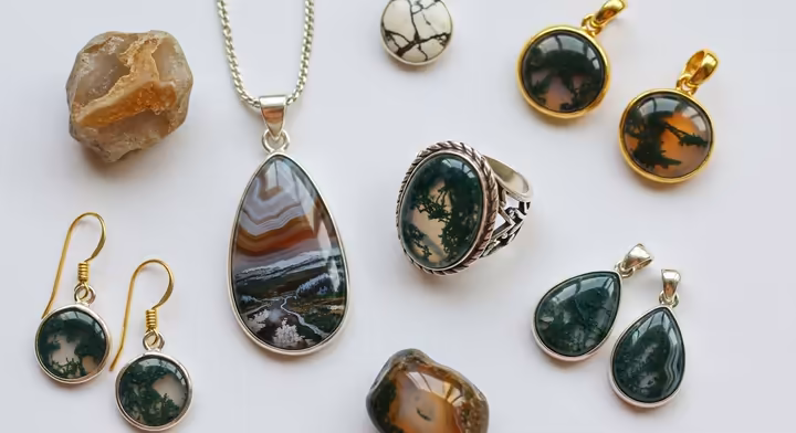 A collection of Montana Agate jewelry, including a pendant with scenic inclusions and a ring with moss agate.