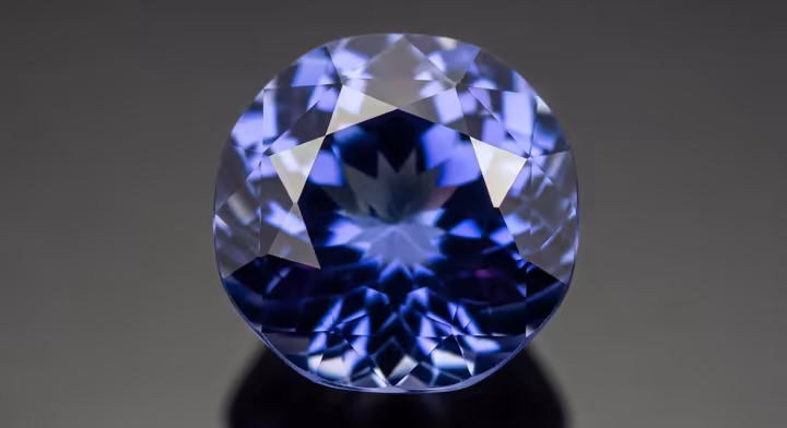 A perfectly cut, sparkling Tanzanite gemstone showing its deep blue and violet colors.